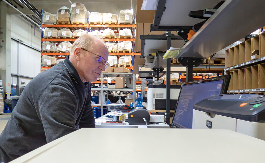 LEON Fulfillment Mitarbeiter überwacht digitale Lagerlogistik am Display.